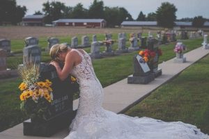 Egy fiatal nő a menyasszonyi ruháját viselte a temetőben, hogy meglátogassa a vőlegényét azon a napon, amikor az esküvőjüknek kellett volna lennie